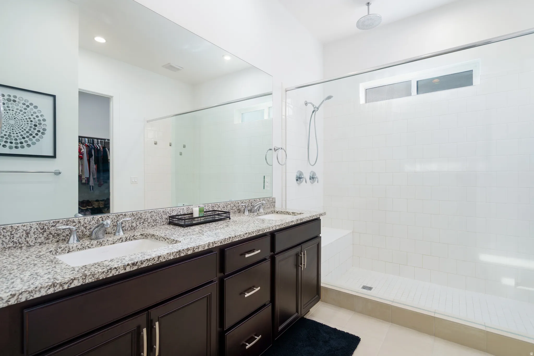 Full bath featuring double vanity, a spacious closet, a large walk in shower.