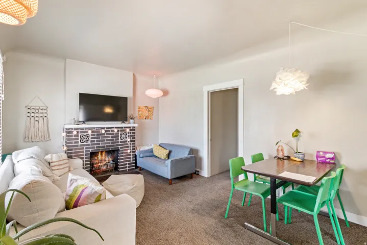 Living room featuring a fireplace, carpet floors, and a chandelier