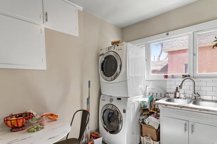 Laundry room featuring cabinet space and stacked washer / drying machine