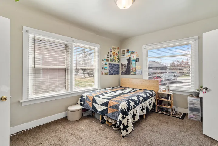 Bedroom featuring light carpet and multiple windows
