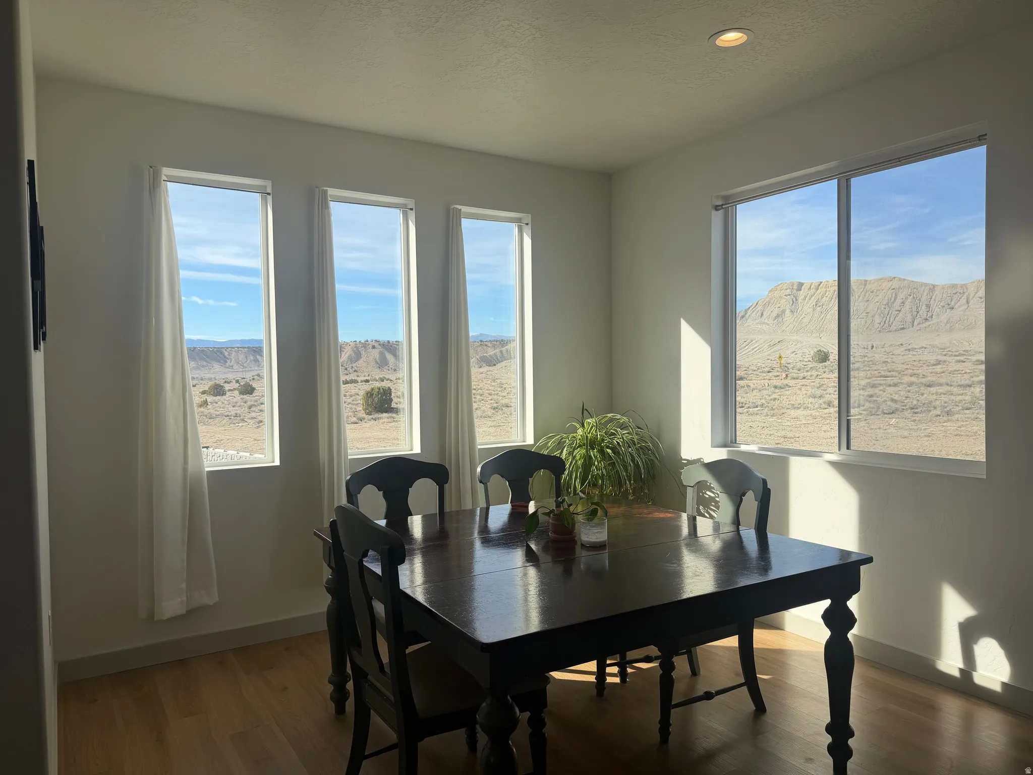 Dining area featuring wood finished floors, a mountain view, a textured ceiling, and recessed lighting