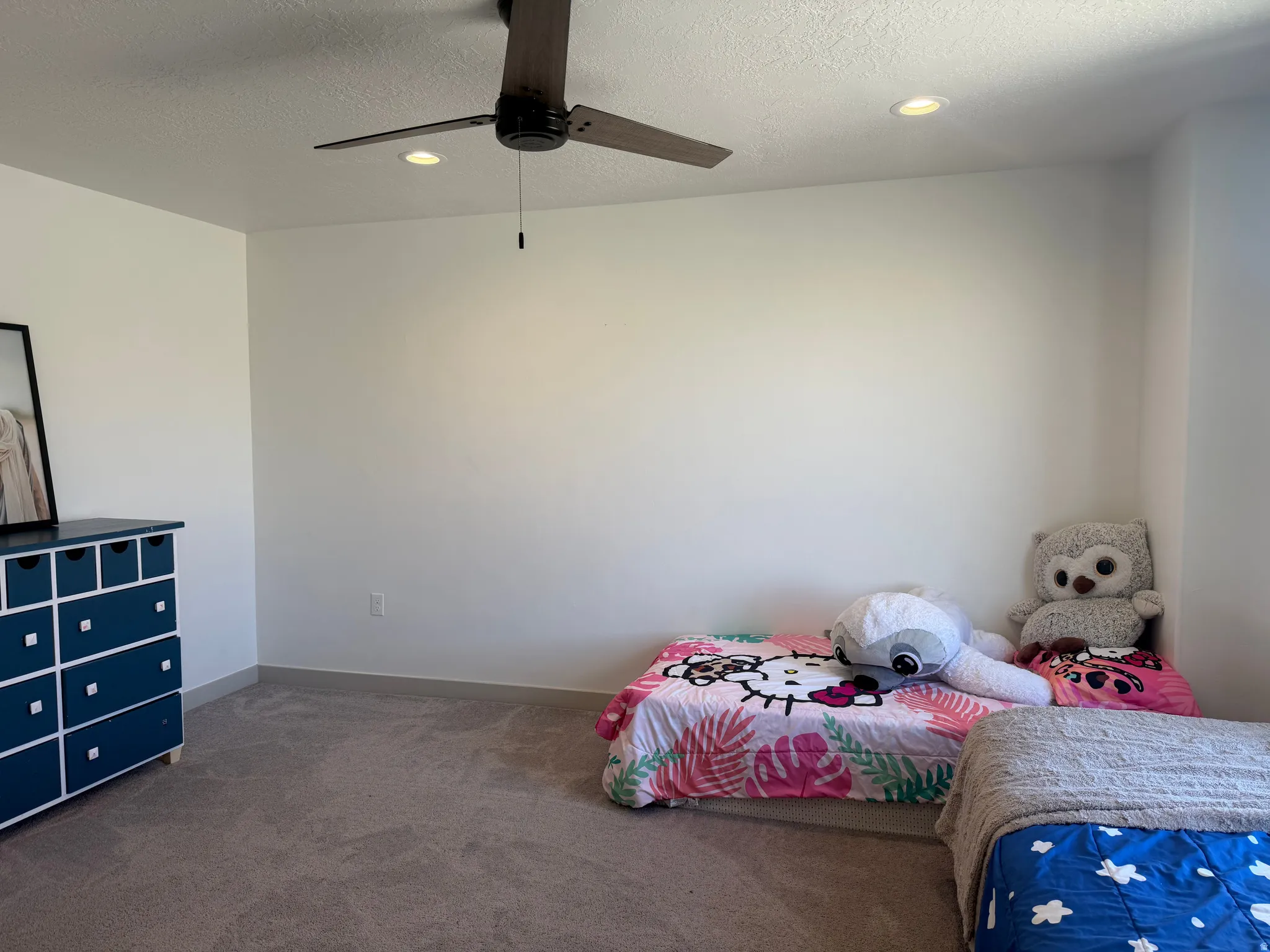 Carpeted bedroom featuring a textured ceiling, ceiling fan, and recessed lighting