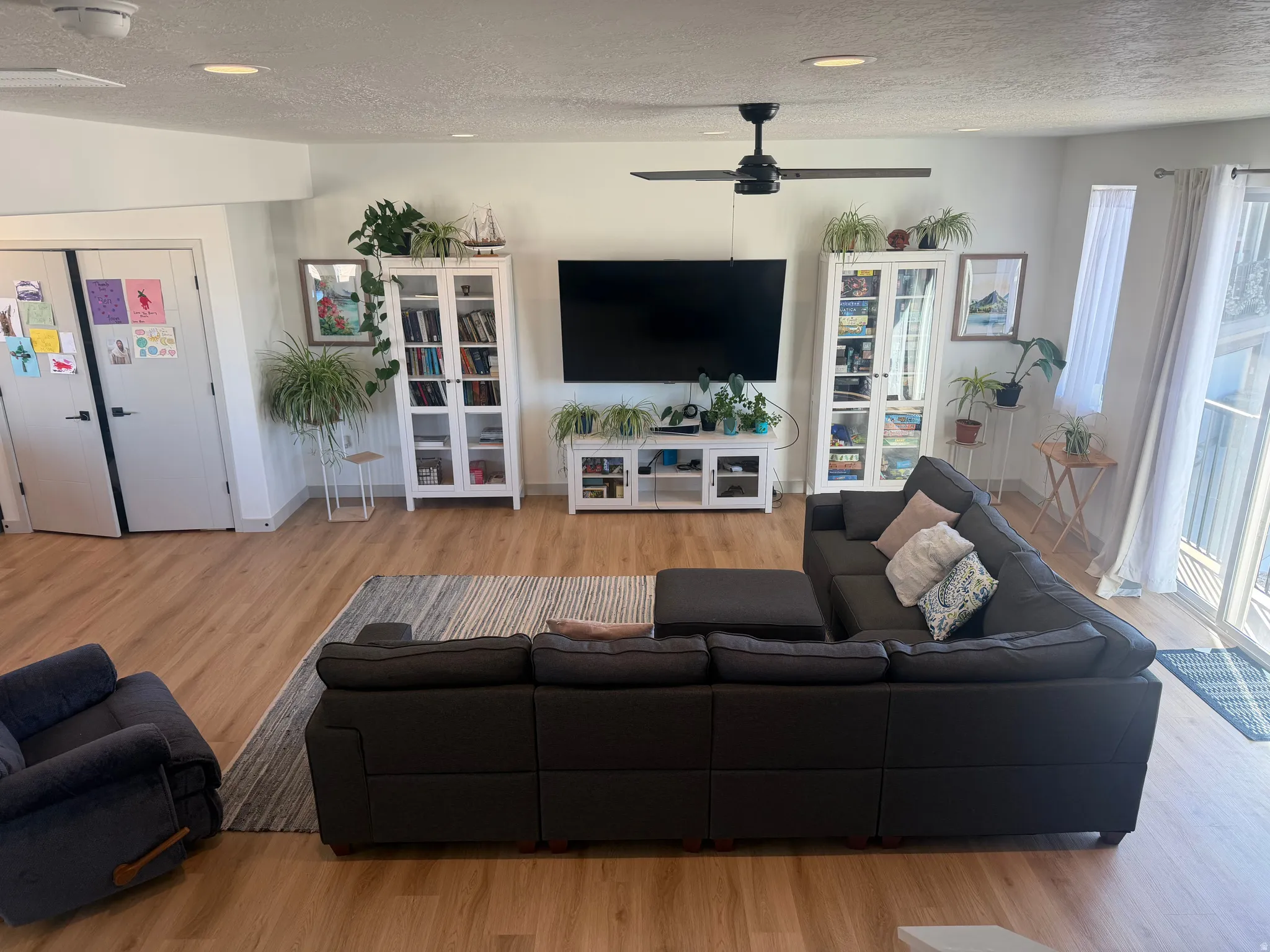Living room featuring light wood-type flooring, a textured ceiling, ceiling fan, and recessed lighting