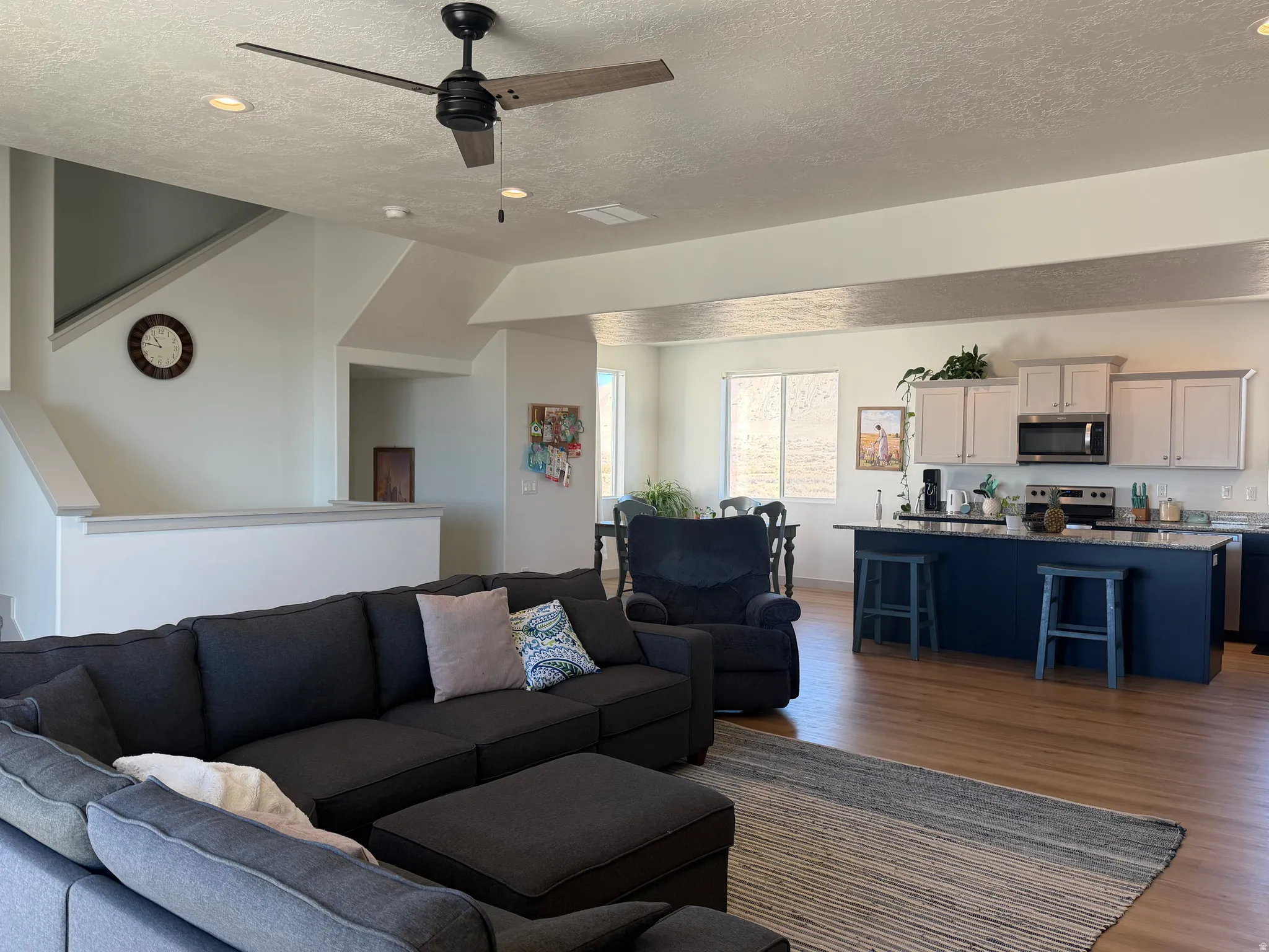 Living area with dark wood-style floors, a ceiling fan, and recessed lighting