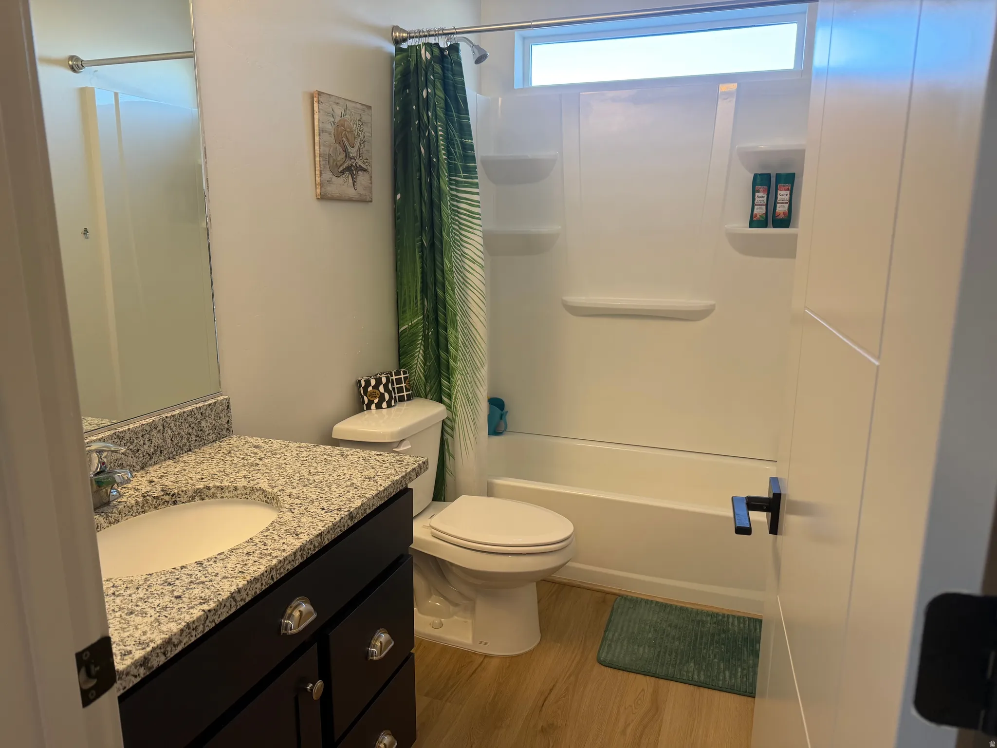 Full bath with vanity, wood finished floors, and shower / bath combo