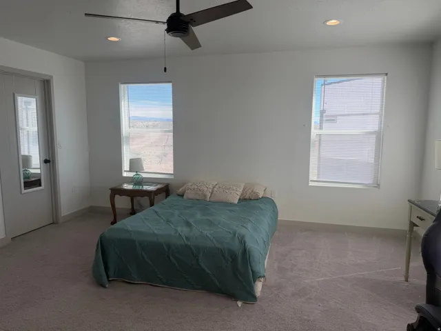 Carpeted bedroom featuring recessed lighting and a ceiling fan