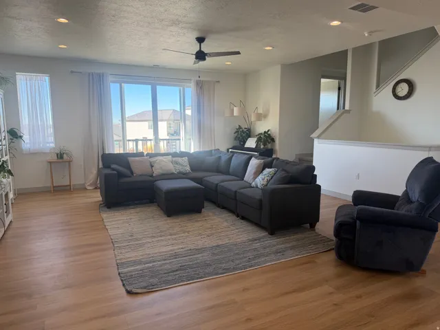 Living area with recessed lighting, a textured ceiling, wood finished floors, and a ceiling fan