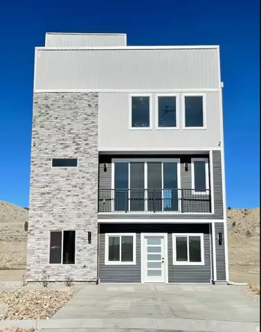 Contemporary house with a balcony and stone siding