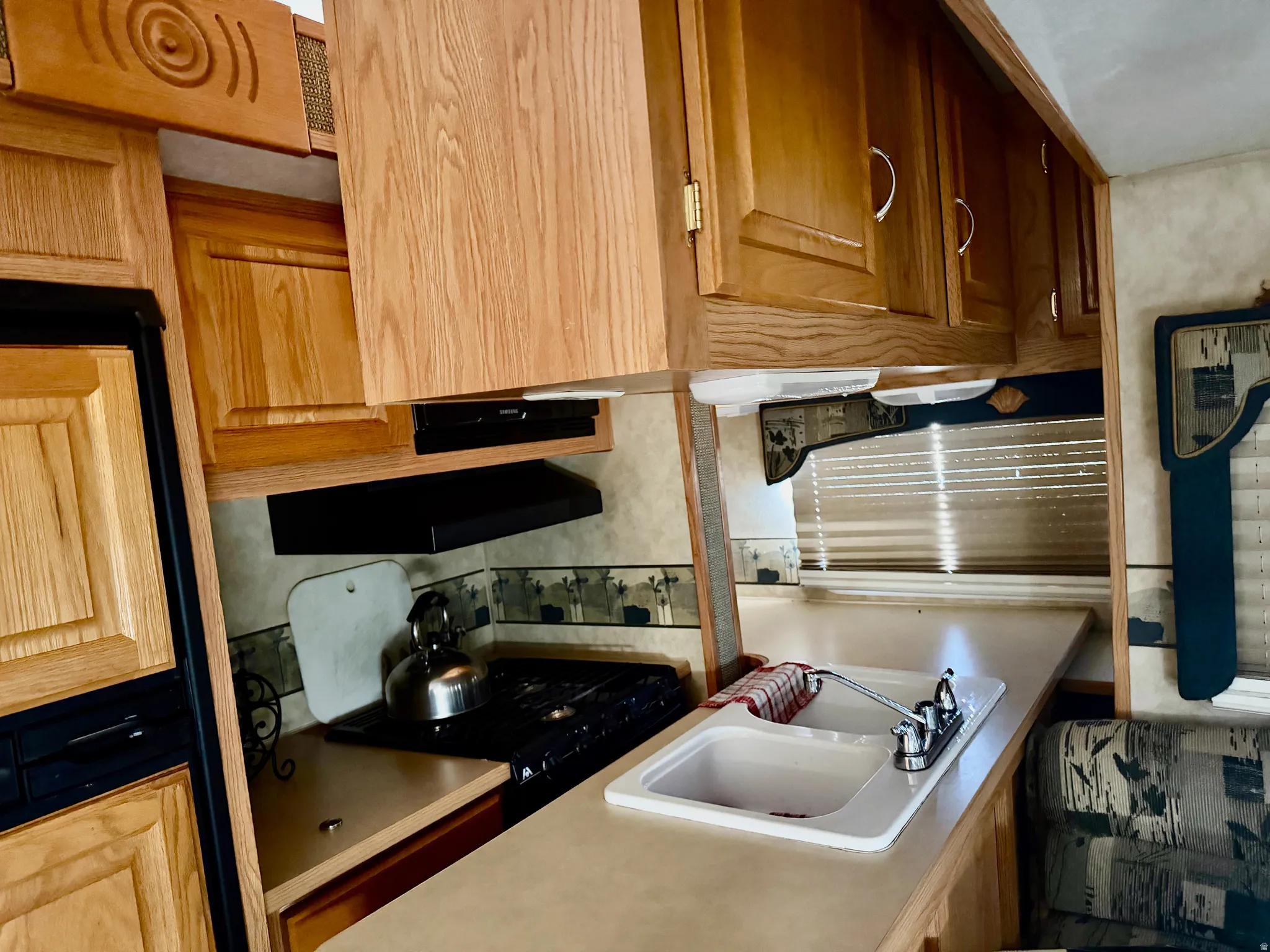 Kitchen with light countertops, dishwashing machine, and black range with gas cooktop