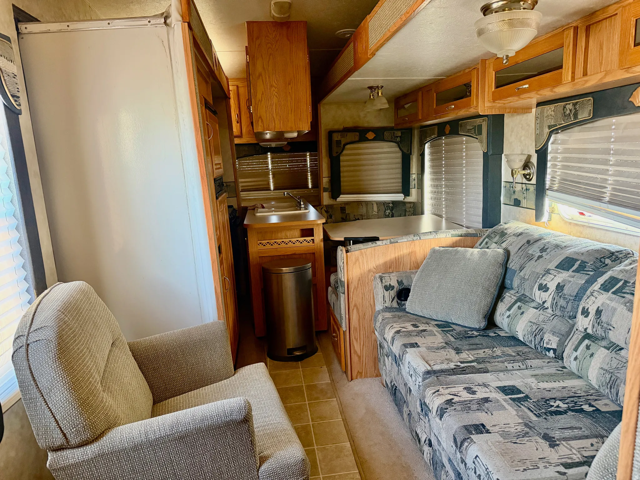 Kitchen with wood finish cabinets, light countertops, and light tile patterned floors