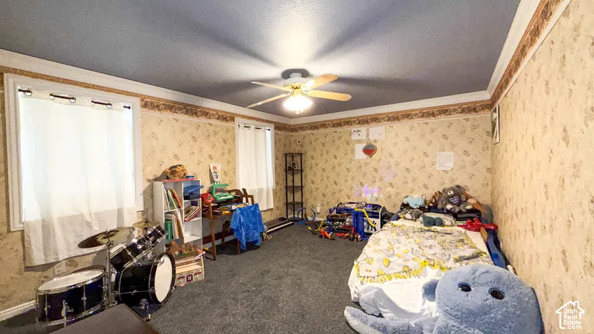 Carpeted bedroom with ornamental molding, ceiling fan, a textured ceiling, and wallpapered walls