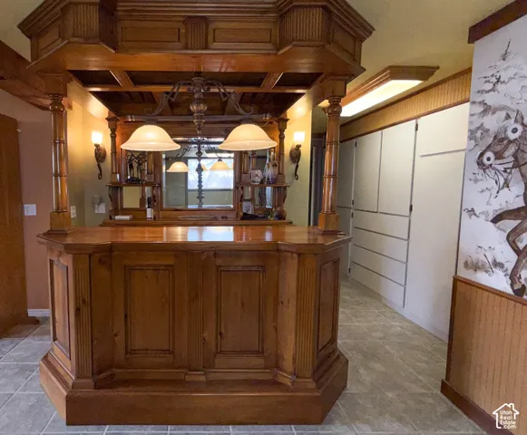 Bar area featuring butcher block counters, wood finish cabinets, and wainscoting