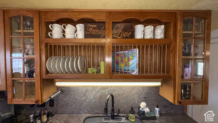 Kitchen view of glass fronted cabinets, decorative backsplash, and wood finish cabinets