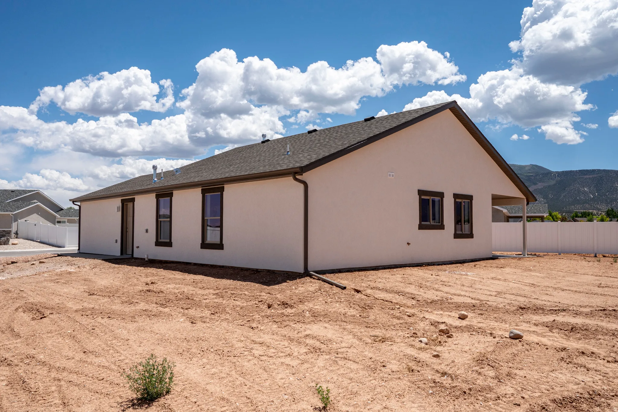 Stucco exterior with dark-trimmed windows and a covered patio