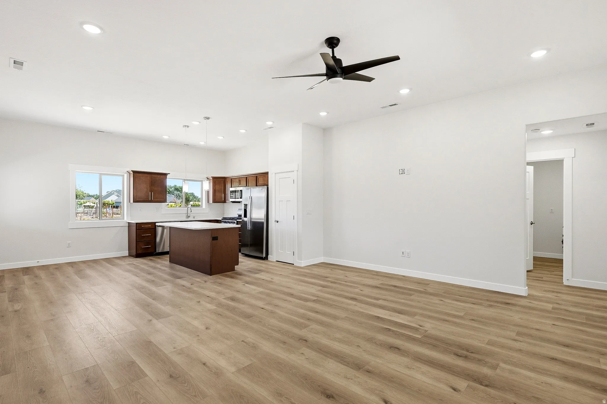 Spacious open-concept living area featuring wood-finish flooring and recessed lighting