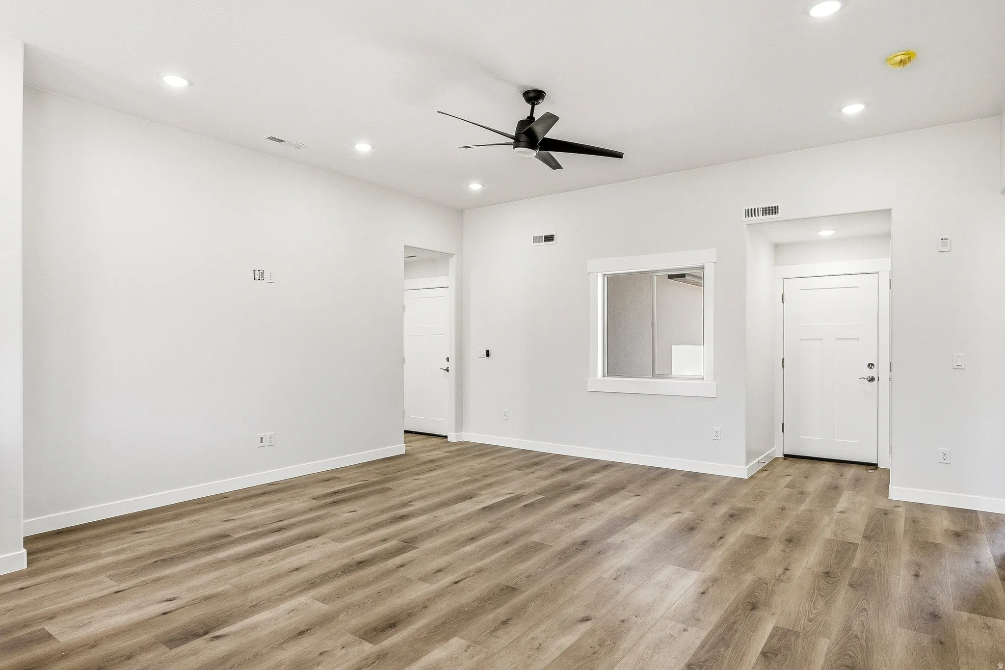Wood-finish flooring, recessed lighting, and a contemporary ceiling fan