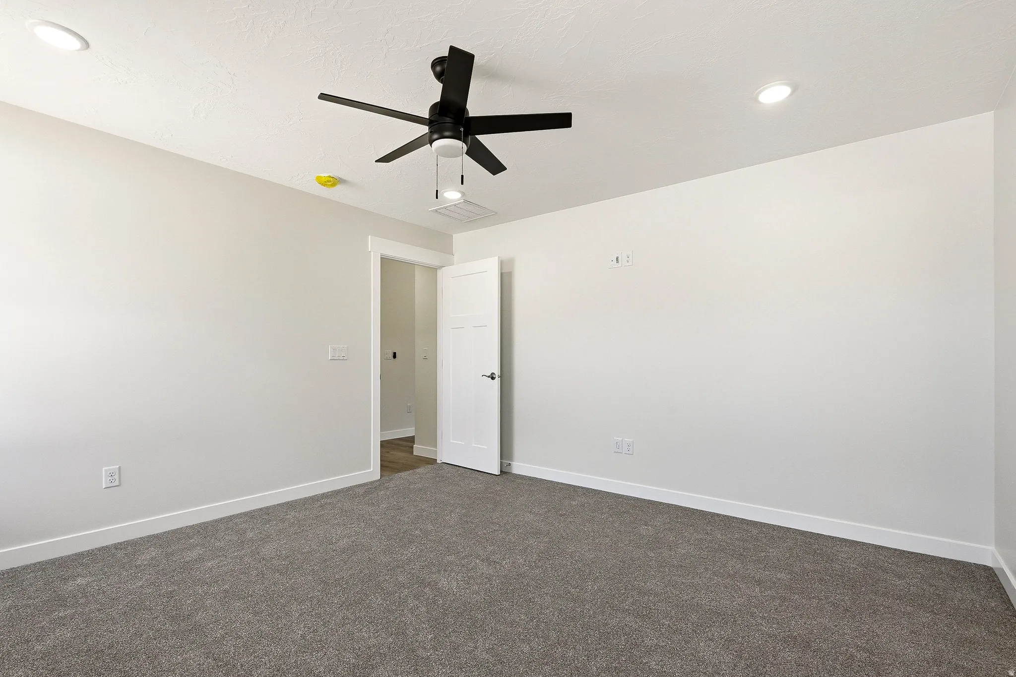 Recessed ceiling lighting, ceiling fan with integrated lighting, textured ceiling finish, light-toned wall paint, and gray carpeting
