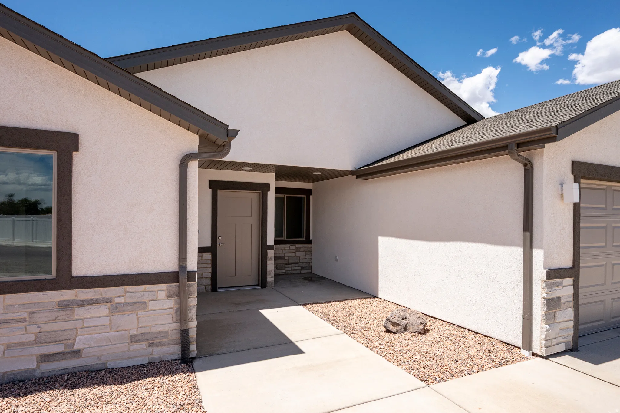 Contemporary exterior with white stucco siding and stone veneer accents