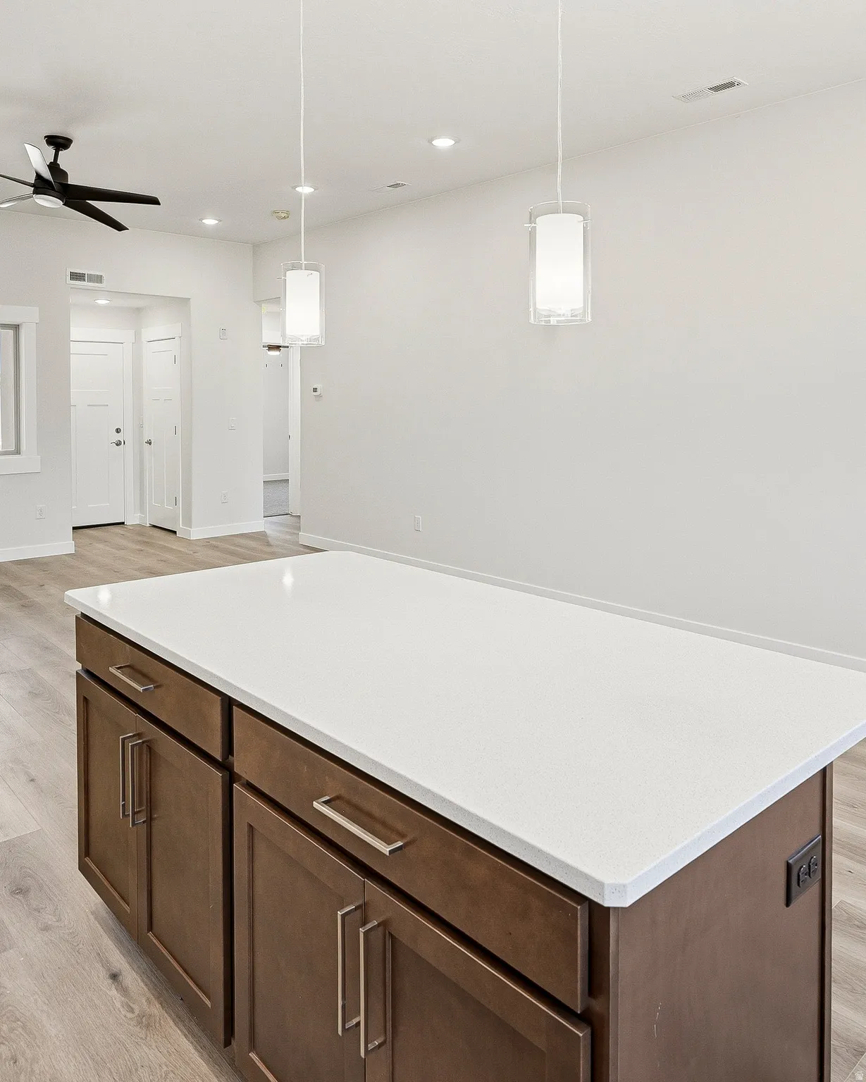 Kitchen island with a white countertop and wood-finish cabinetry