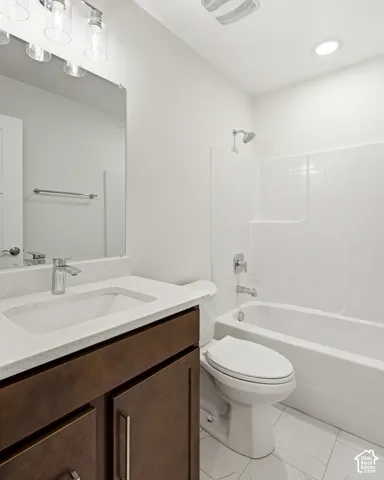 Vanity with a light-toned countertop, integrated sink, and wood-finish cabinetry