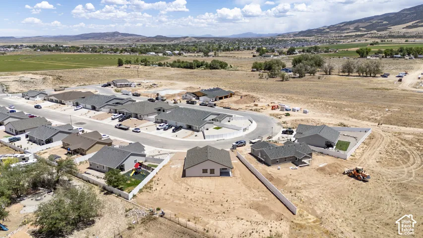 Aerial presentation of new construction homes with partial fencing and surrounding undeveloped land