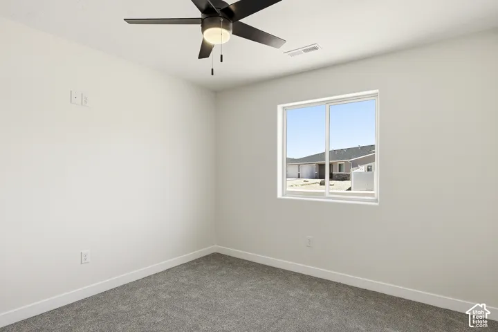 Recessed lighting, wall-mounted ceiling fan, neutral wall paint, gray carpet, and a white-framed window