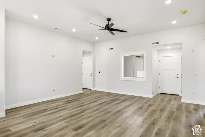 Wood-finish flooring, recessed lighting, and a contemporary ceiling fan