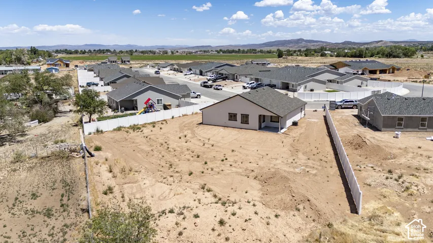 Newly constructed residence with a gray shingle roof, light-colored siding, and a rear patio