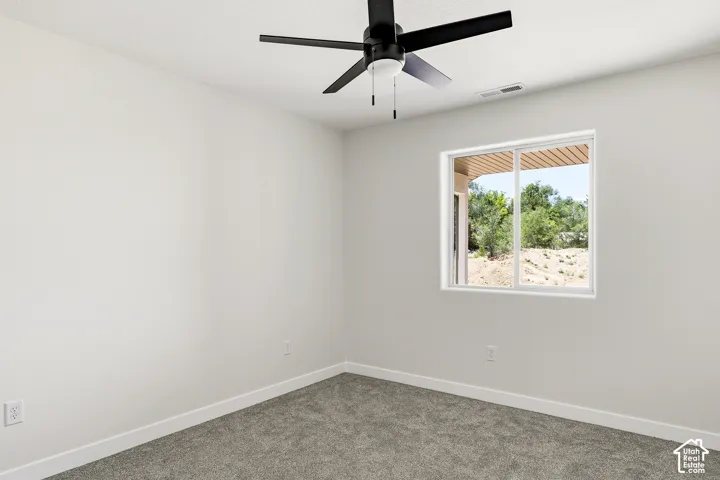 Recessed window with exterior scenery, overhead ceiling fan with light, light-toned walls, and carpeted flooring