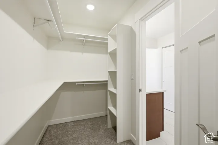 Walk-in closet featuring built-in shelving, hanging rods, and recessed lighting