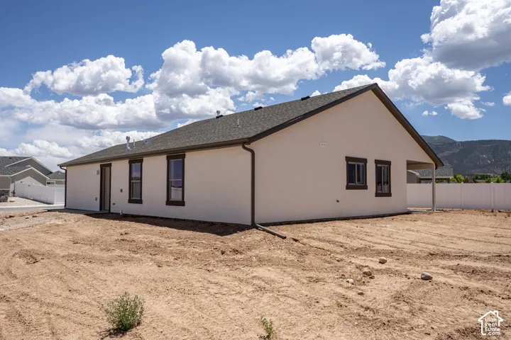 Stucco exterior with dark-trimmed windows and a covered patio