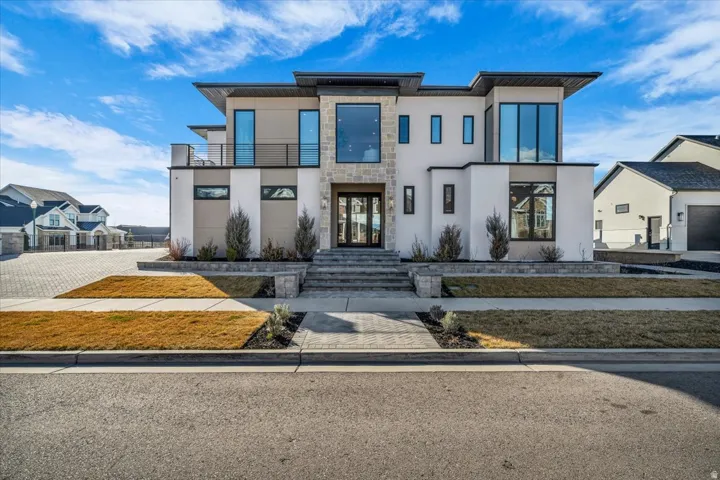 Contemporary home with stucco siding, a balcony, and stone siding
