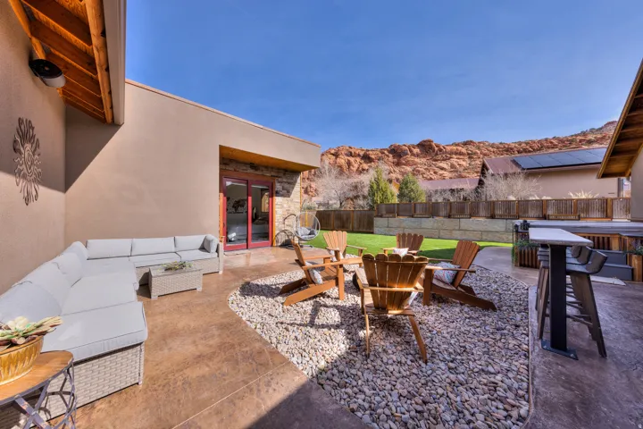 Fenced backyard featuring a patio, an outdoor lounge area with bar, french doors, and an outdoor fire pit