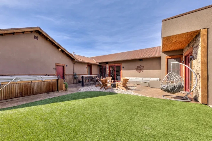 View of green lawn with a hot tub, a patio area, and an outdoor living space with a fire pit