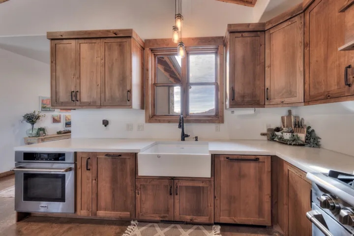 Kitchen featuring stainless steel appliances, light countertops, and wood finish cabinets