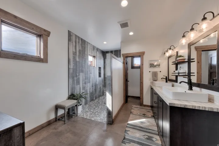 Full bathroom with double vanity, finished concrete floors, a walk in shower, and recessed lighting