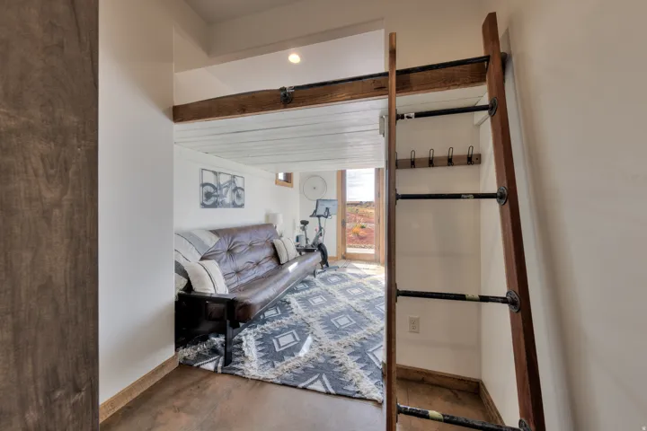 Living area with baseboards and beamed ceiling