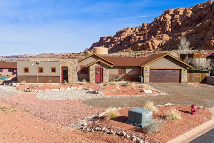 View of front of property featuring stone siding, a mountain view, stucco siding, and a garage