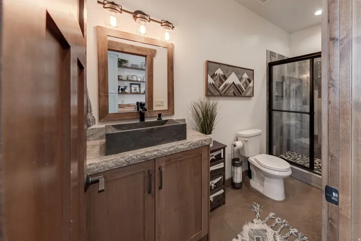 Full bathroom featuring vanity, a shower stall, concrete floors, and recessed lighting