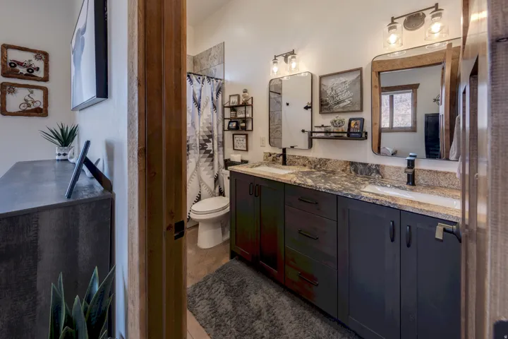 Bathroom with double vanity and a shower with shower curtain