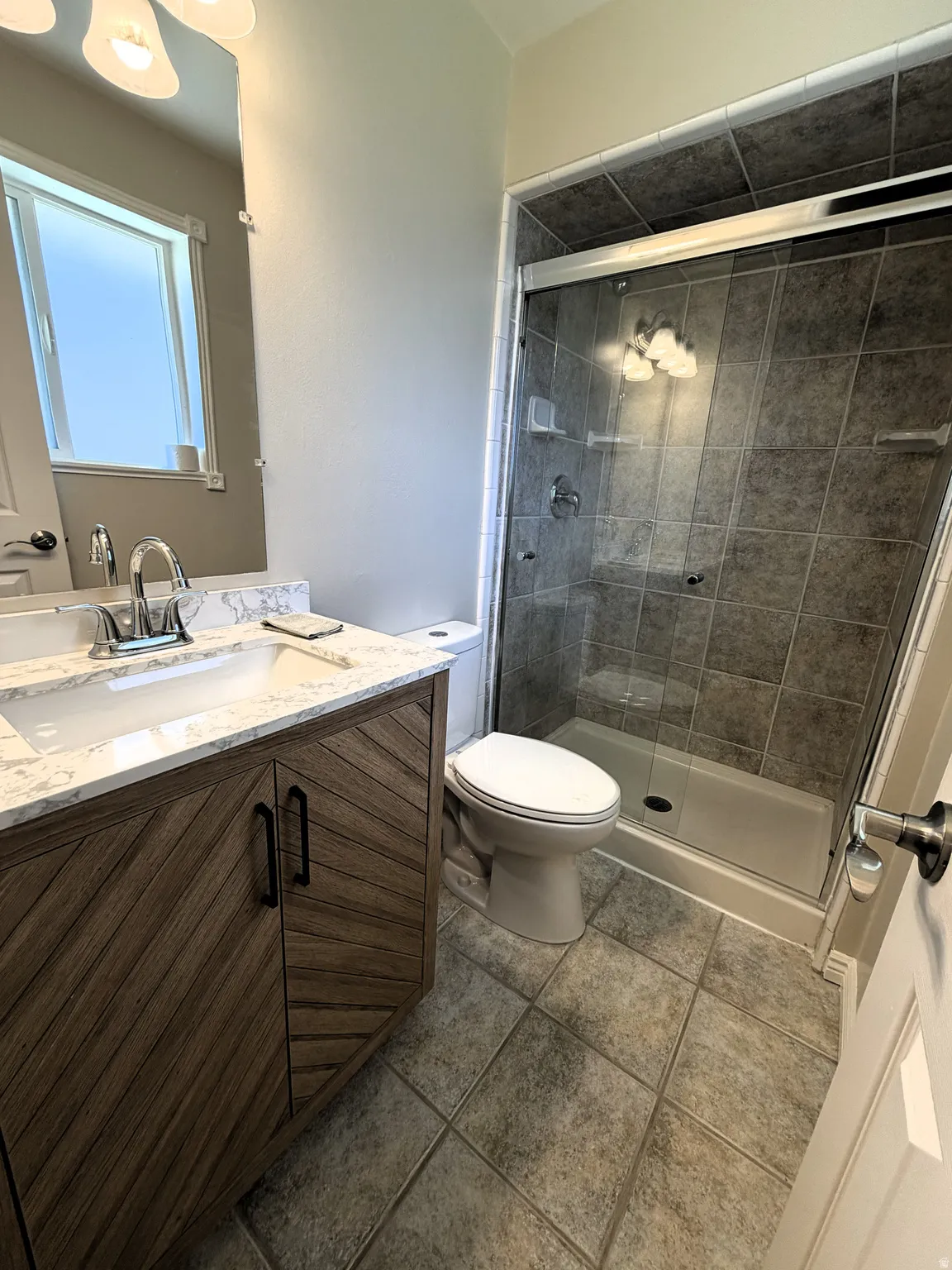 Main Suite Bathroom featuring vanity, a shower stall, and light tile patterned flooring