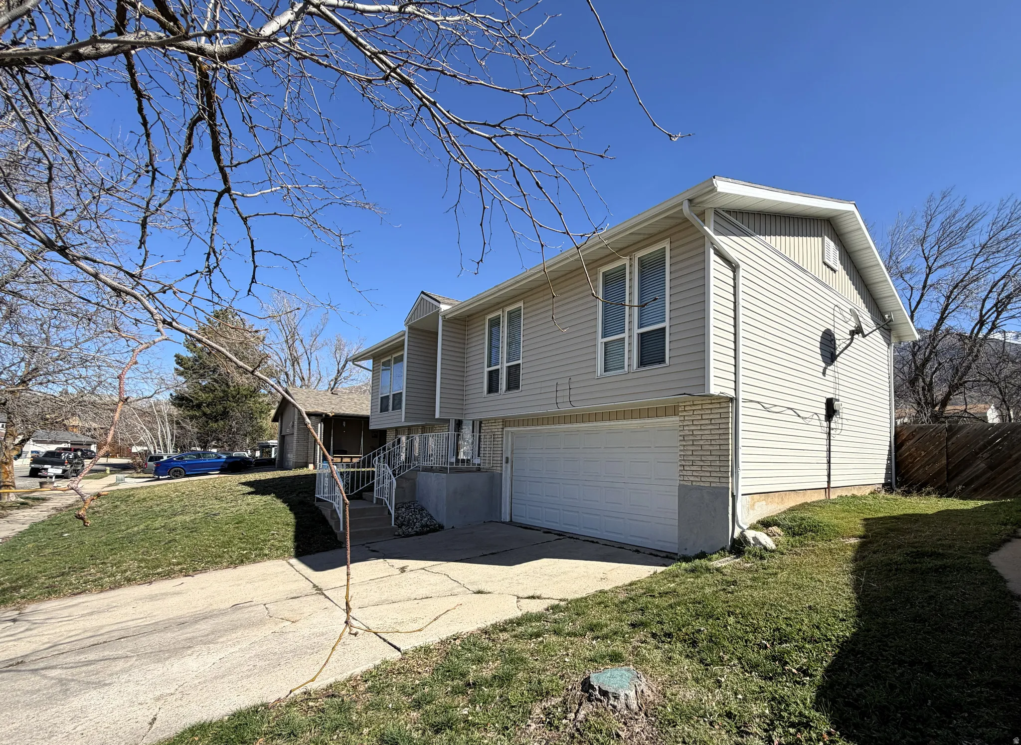 View of home's exterior with a yard, concrete driveway, a garage, and brick siding