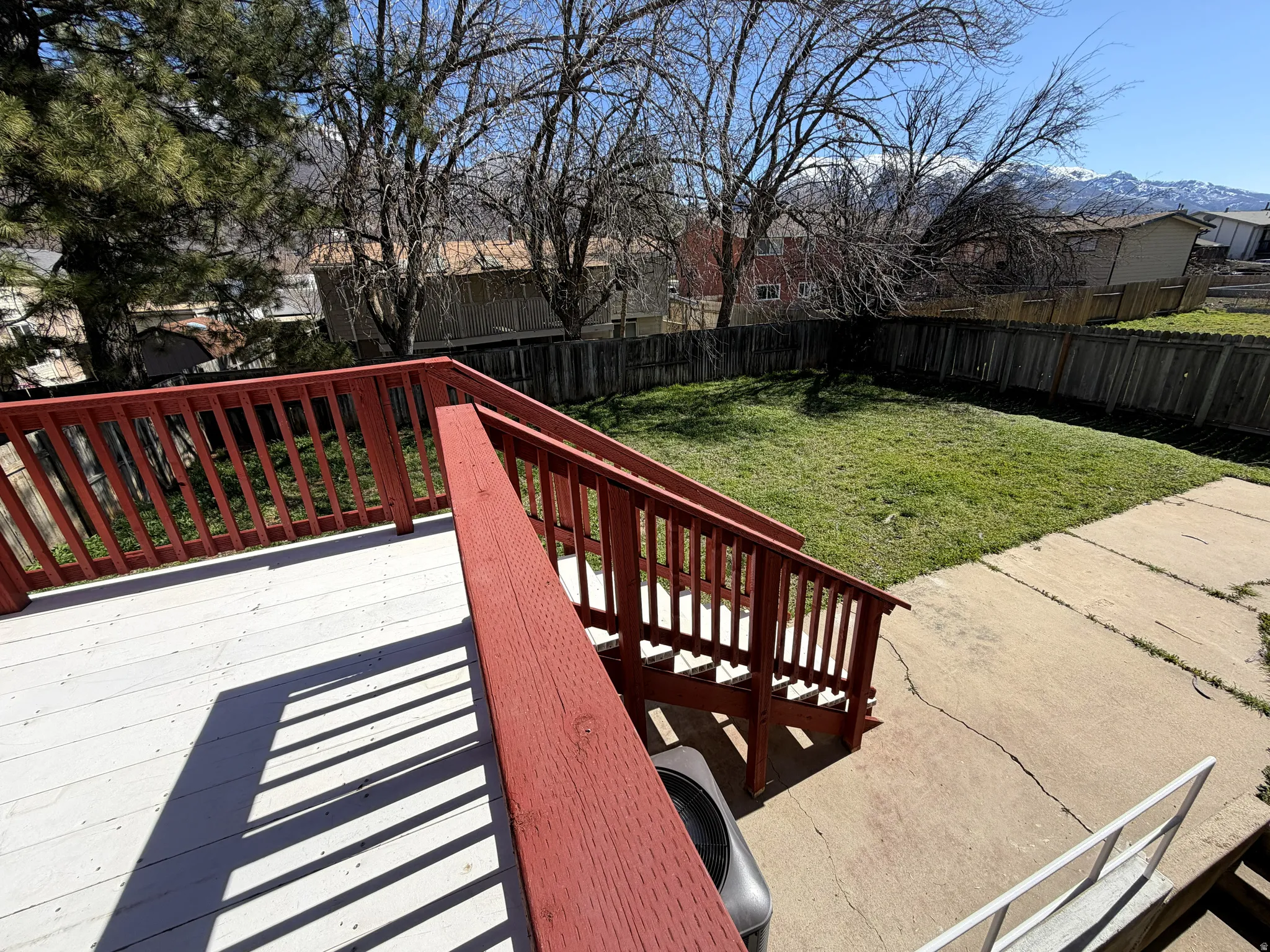 Wooden terrace featuring a fenced backyard and a residential view