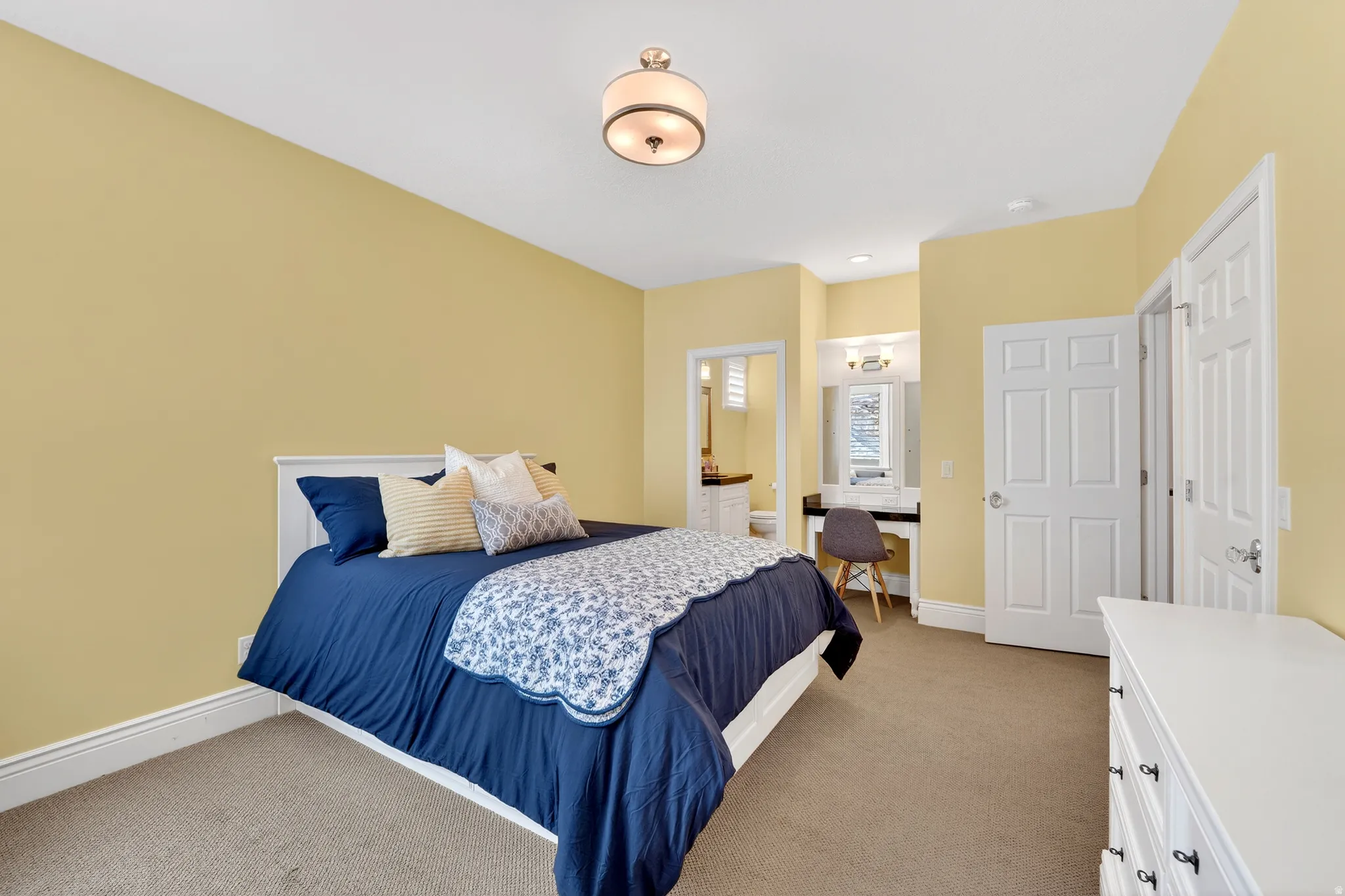 Bedroom featuring built in bed, light colored carpet and ensuite bath