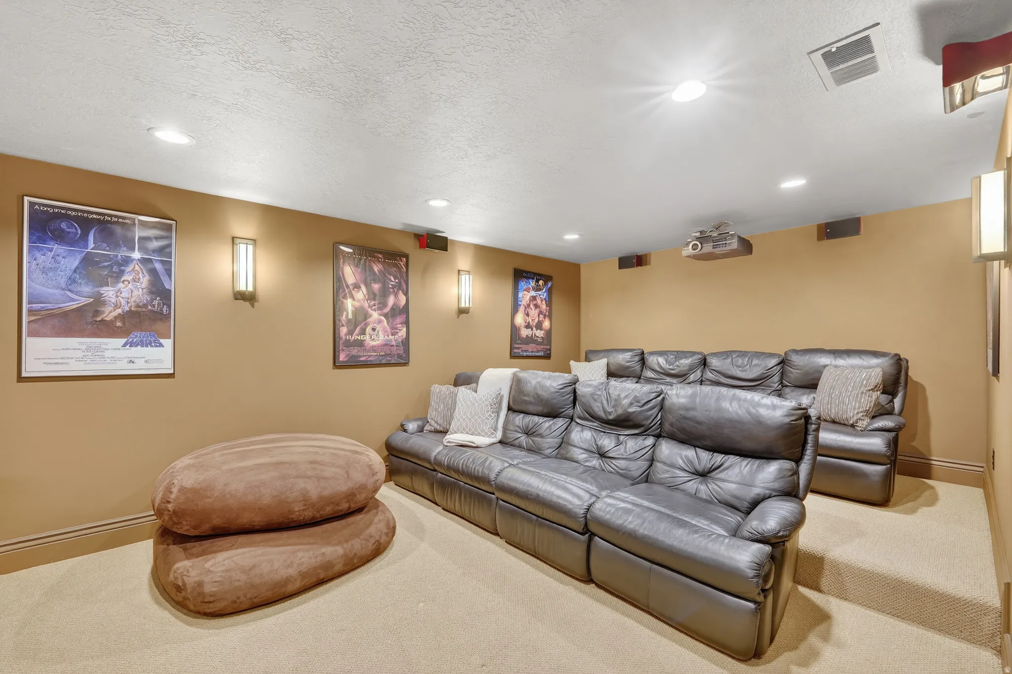 Carpeted cinema room with a textured ceiling and recessed lighting