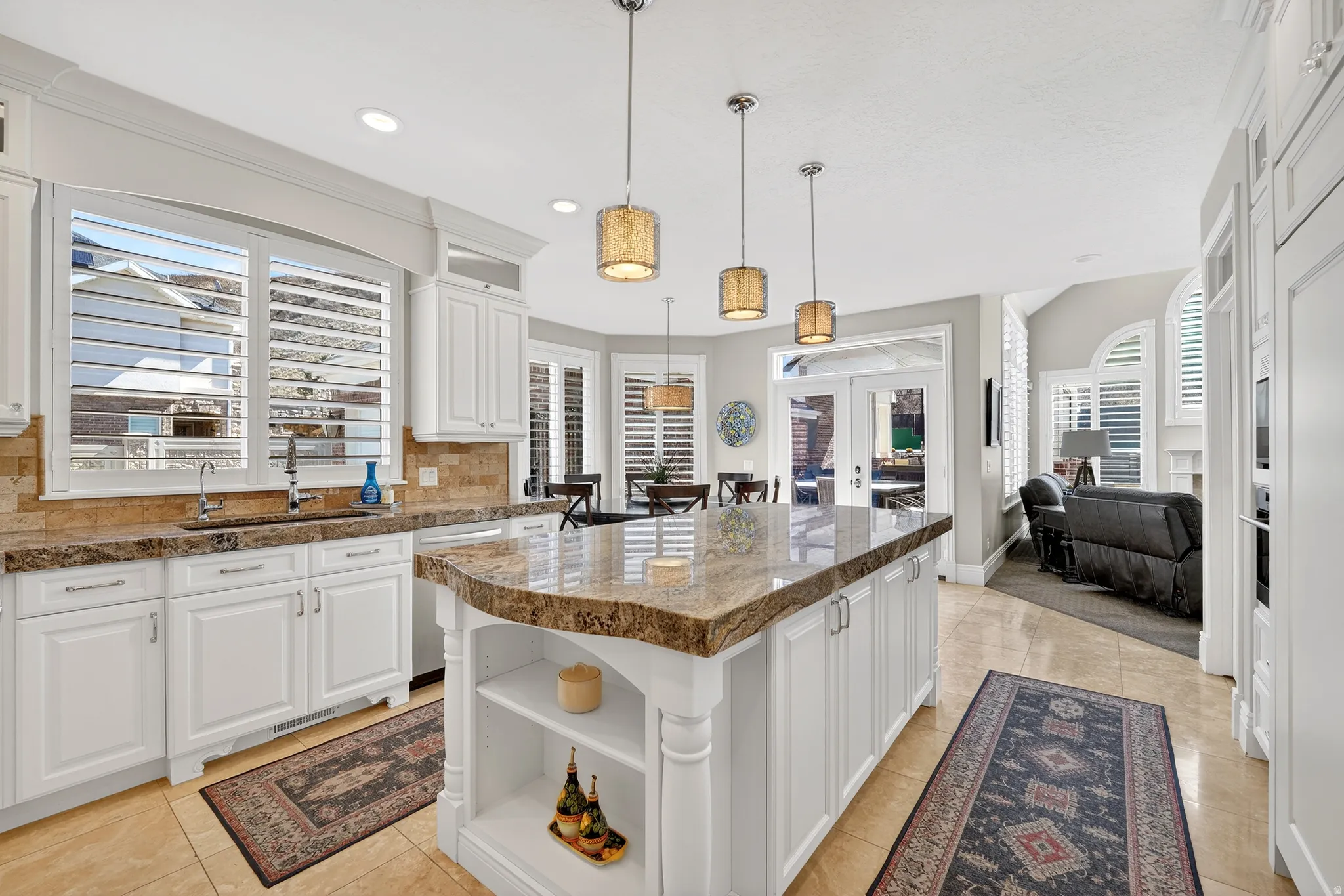 Kitchen with open shelves, french doors, white cabinets, tasteful backsplash, and a center island