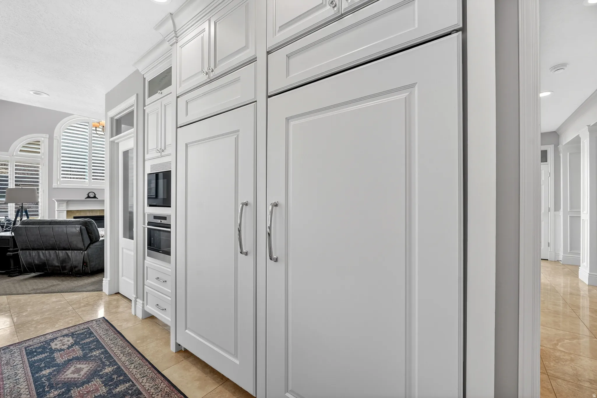 Kitchen with recessed lighting, white cabinets, a fireplace, oven, and black microwave