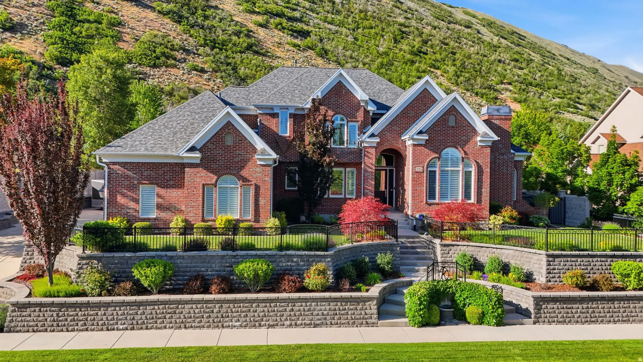 Brick exterior featuring a multi-level architectural design and a grey shingle roof