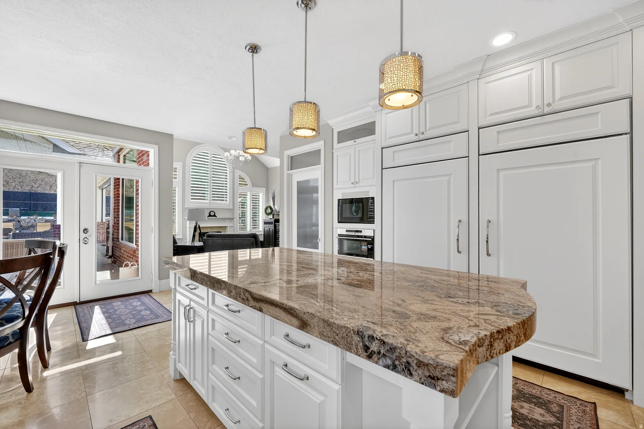 Kitchen featuring white cabinets, french doors, a kitchen island, built in appliances, and glass fronted cabinets