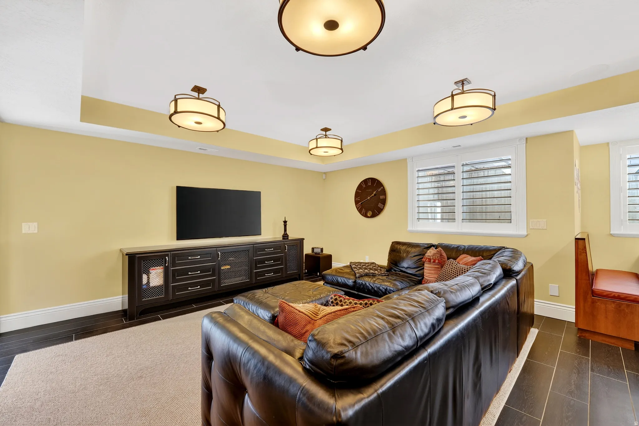 Living area featuring a raised ceiling, wood tiled floors, and healthy amount of natural light